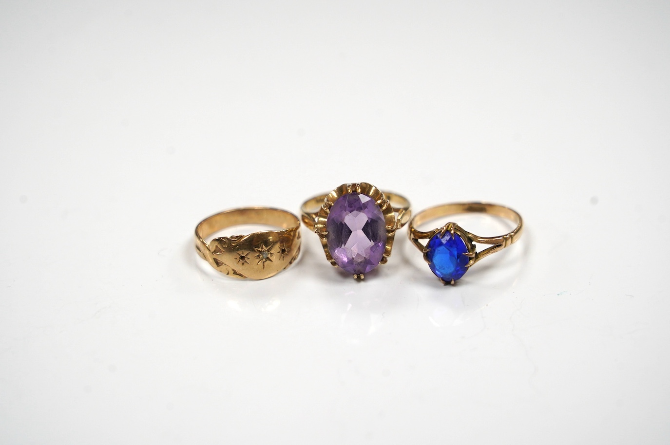 A modern 9ct gold and amethyst set dress ring, a 9ct and diamond chip set ring and a yellow metal (stamped 15c) and blue stone set ring, gross weight 8.2 grams. Condition - poor to fair